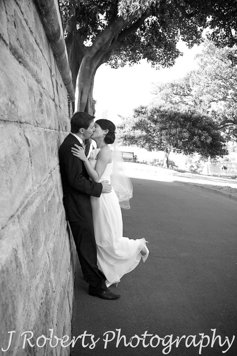 Bride and groom kissing up again the wall of the Observatory Sydney - wedding photography sydney